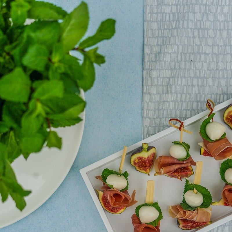 Prosciutto and mozzarella skewers on a white tray